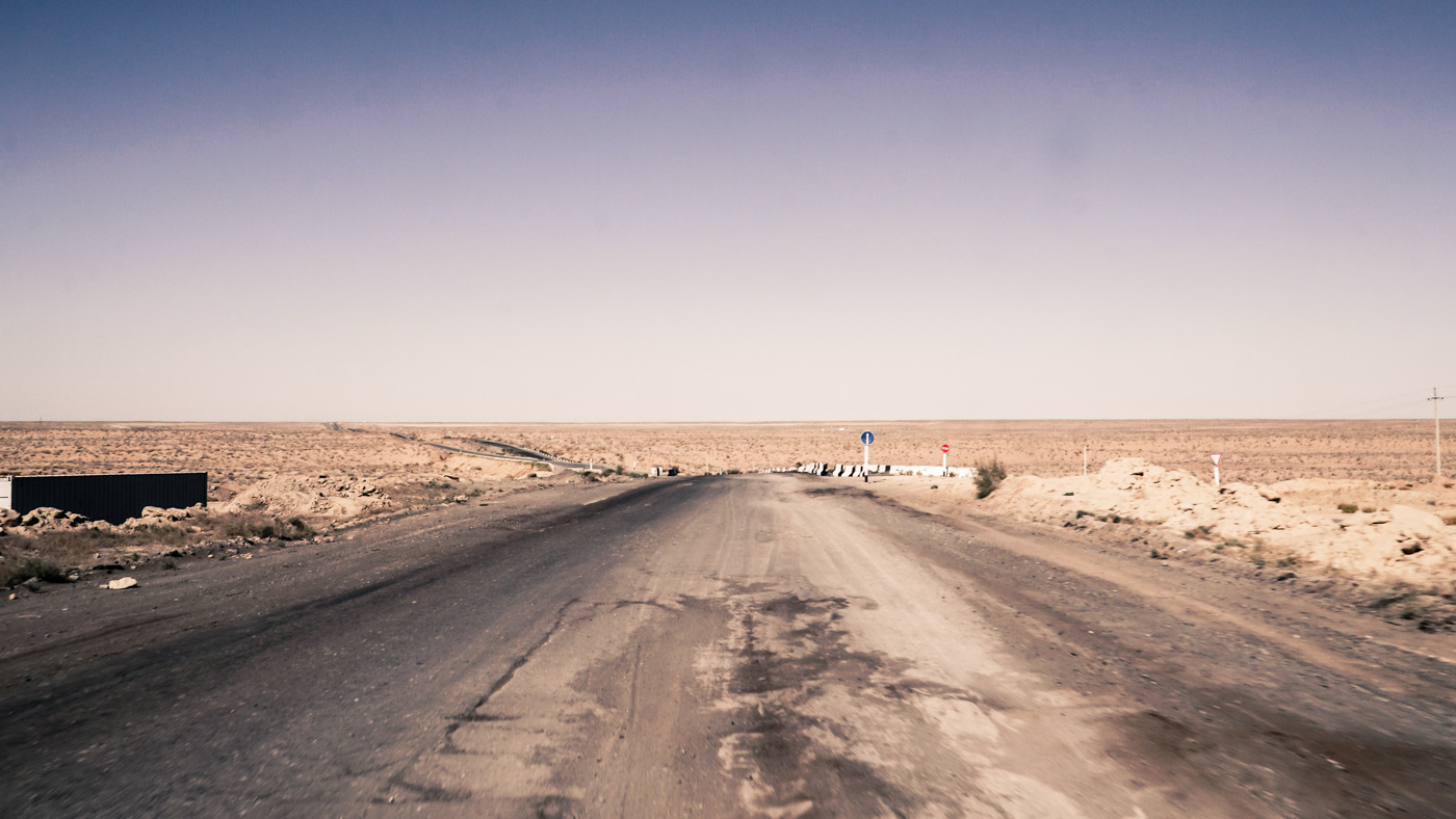 The road in Kyrgyzstan full of depressions and holes crossing a desert