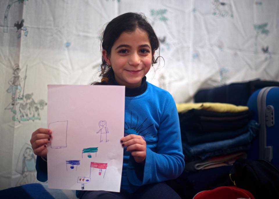 Pequena garota da Síria segurando um desenho