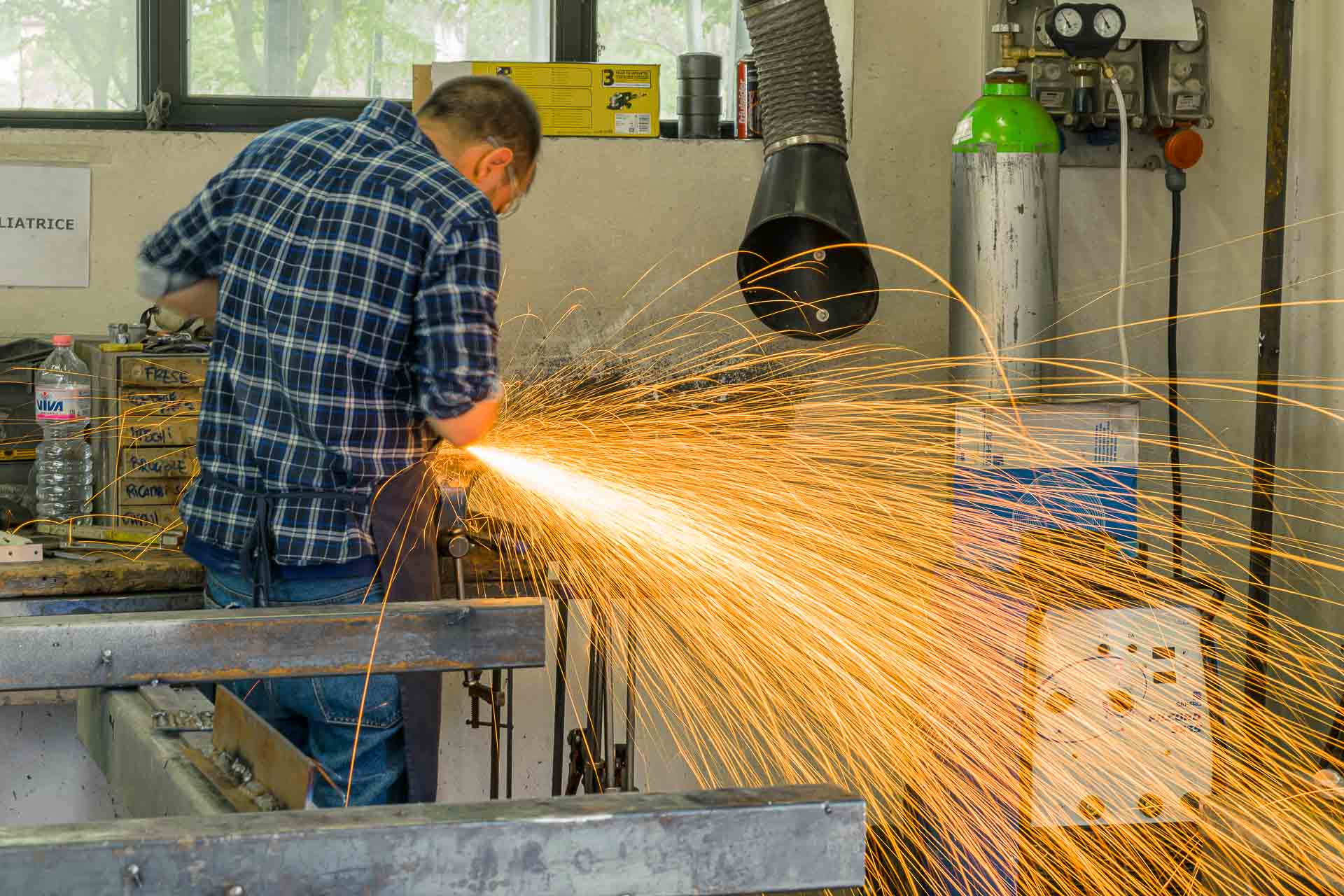 The bike mechanic cutting steel making a large fire sparks in a bike shop