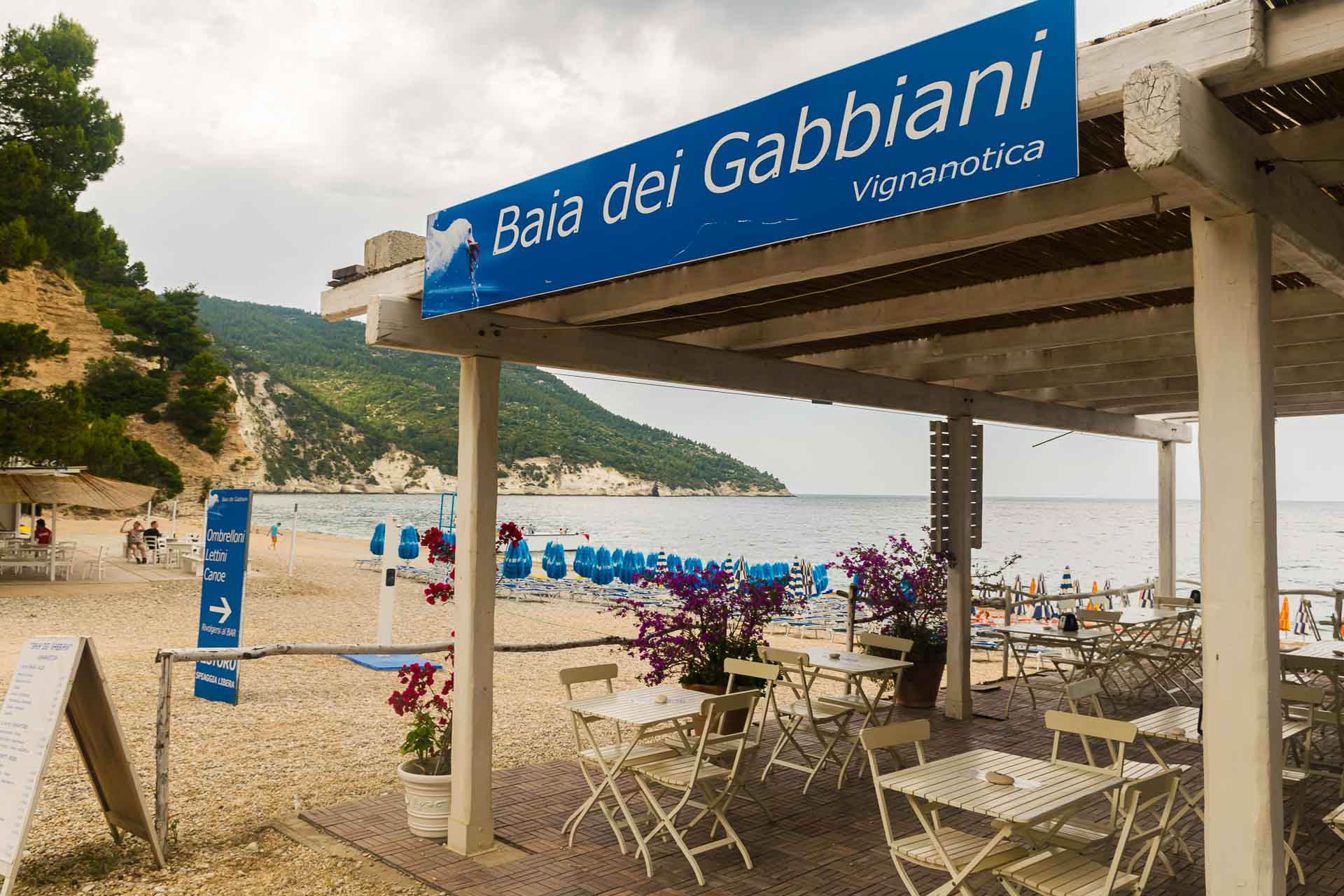 beach stall with chairs and table written Baia dei Gabbiani, one of the beaches in the Gargano, Puglia