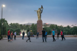 Kyrgyzstan tourist attractions Statue to the Martyrs of the Revolution and people playing volleyball in Bishkek