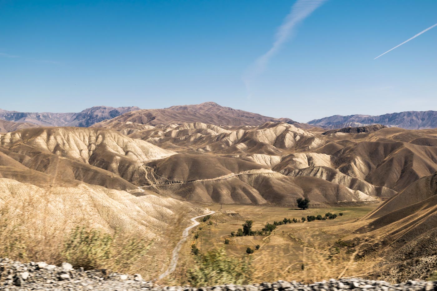 estrada de terra indo pelas montanhas do Quirguistão