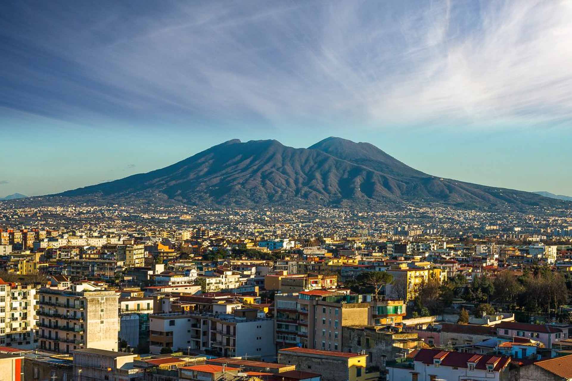 An overview of Naples with a large mountain in the background