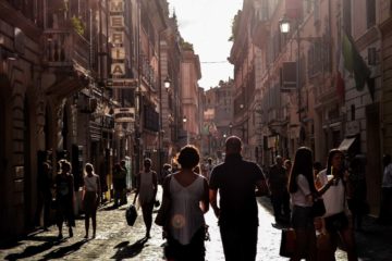 People walking against the sun light in the streets of Naples