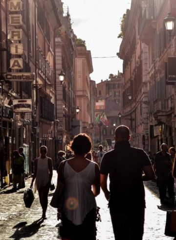 People walking against the sun light in the streets of Naples