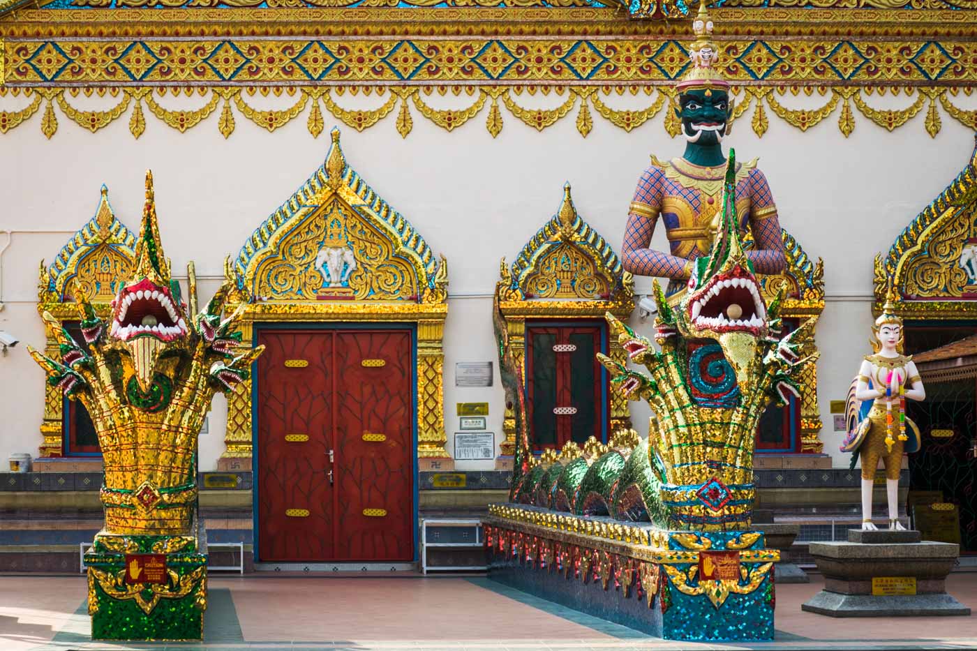 The entrance of a Buddhist temple with detailed art and ornaments in front