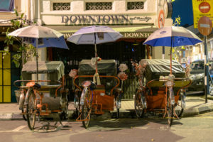 tuktuks estacionados com guarda-chuvas nas ruas de Penang
