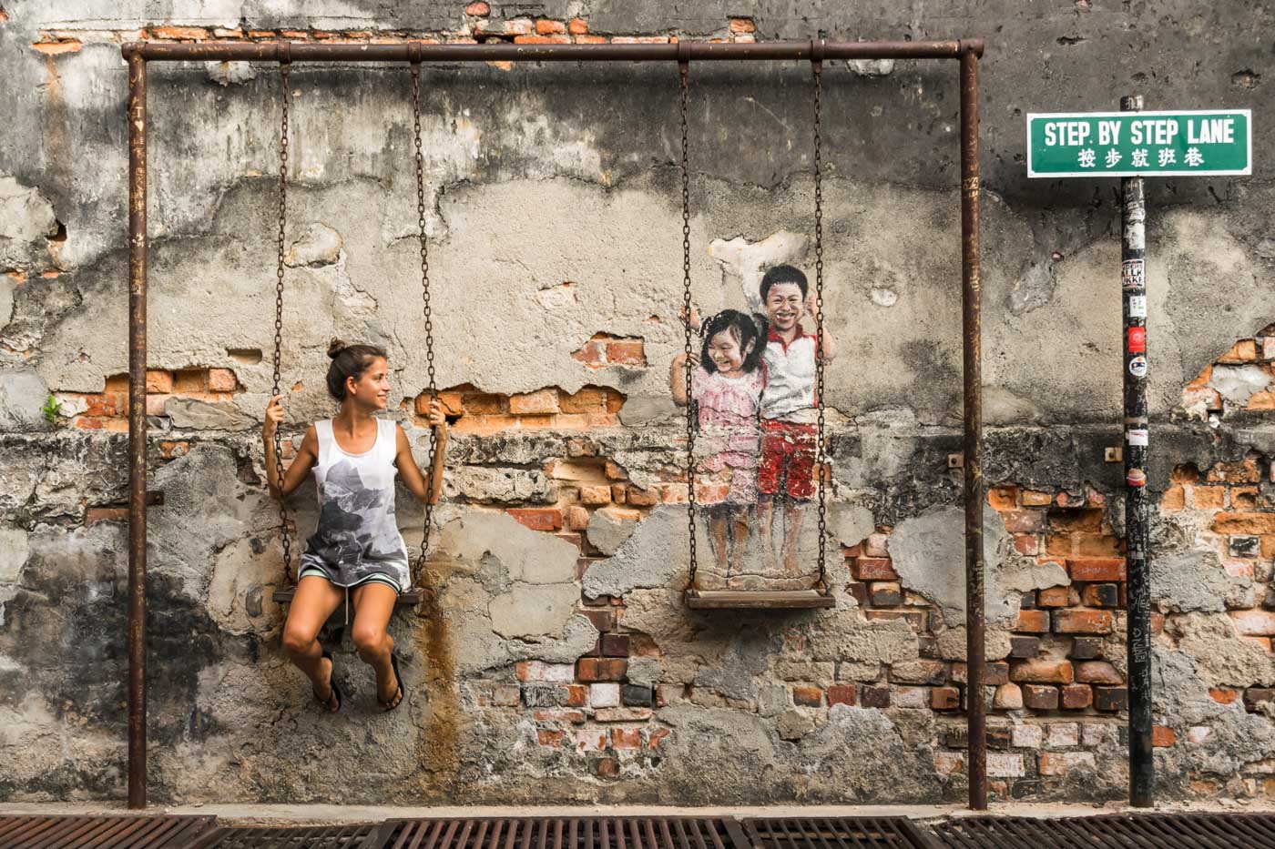 Fernanda sentada em um balanço de criança preso na parede como em forma de arte