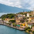 Vista de Limone sul Garda na Italia com a cidade na beira do lago e a igreja na parte mais alta da cidade