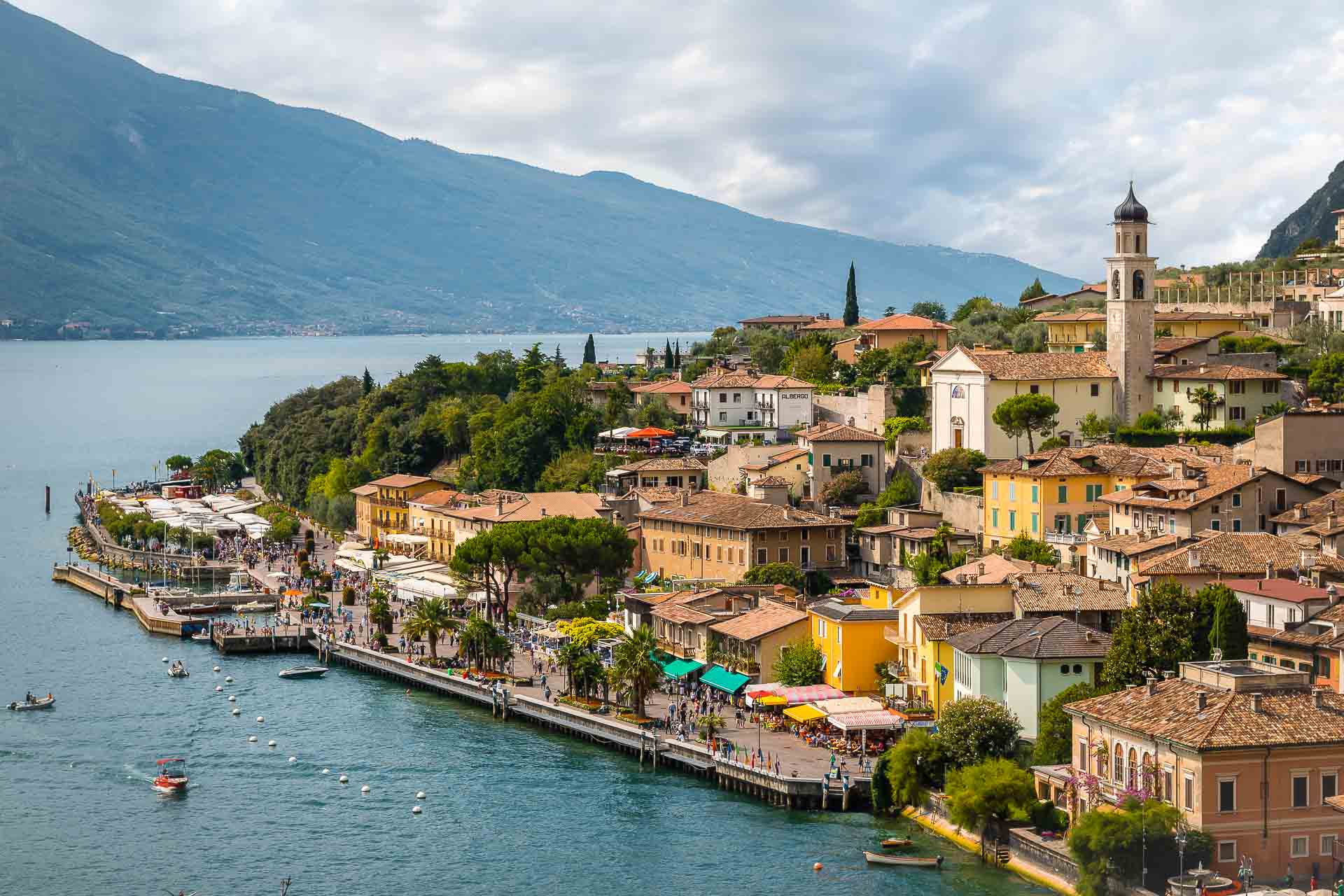 Vista de Limone sul Garda na Italia com a cidade na beira do lago e a igreja na parte mais alta da cidade