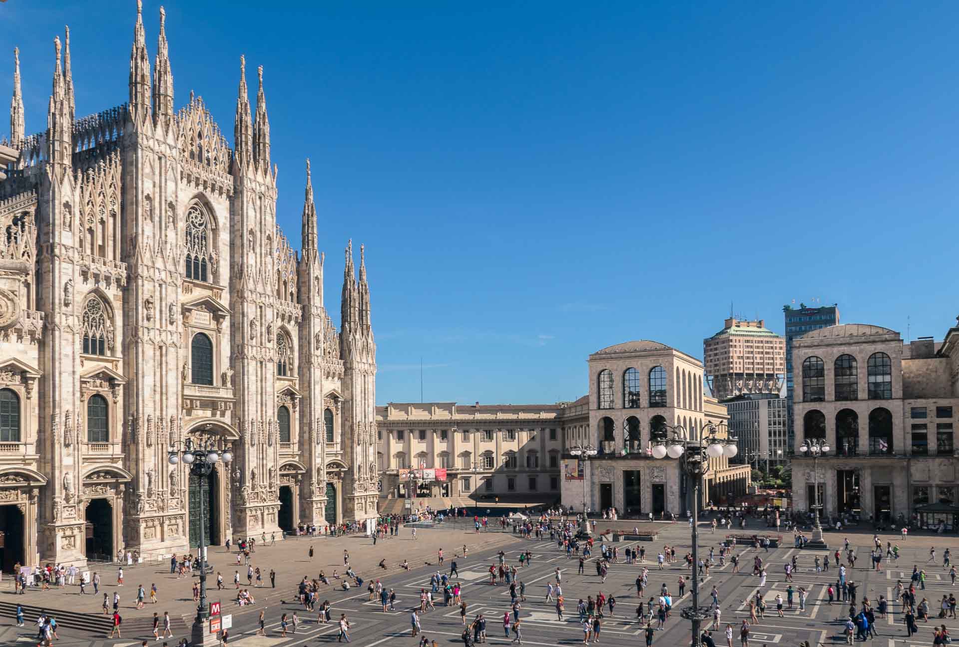 Vista da praça principal de Milão com o duomo de Milão e muitas pessoas andando