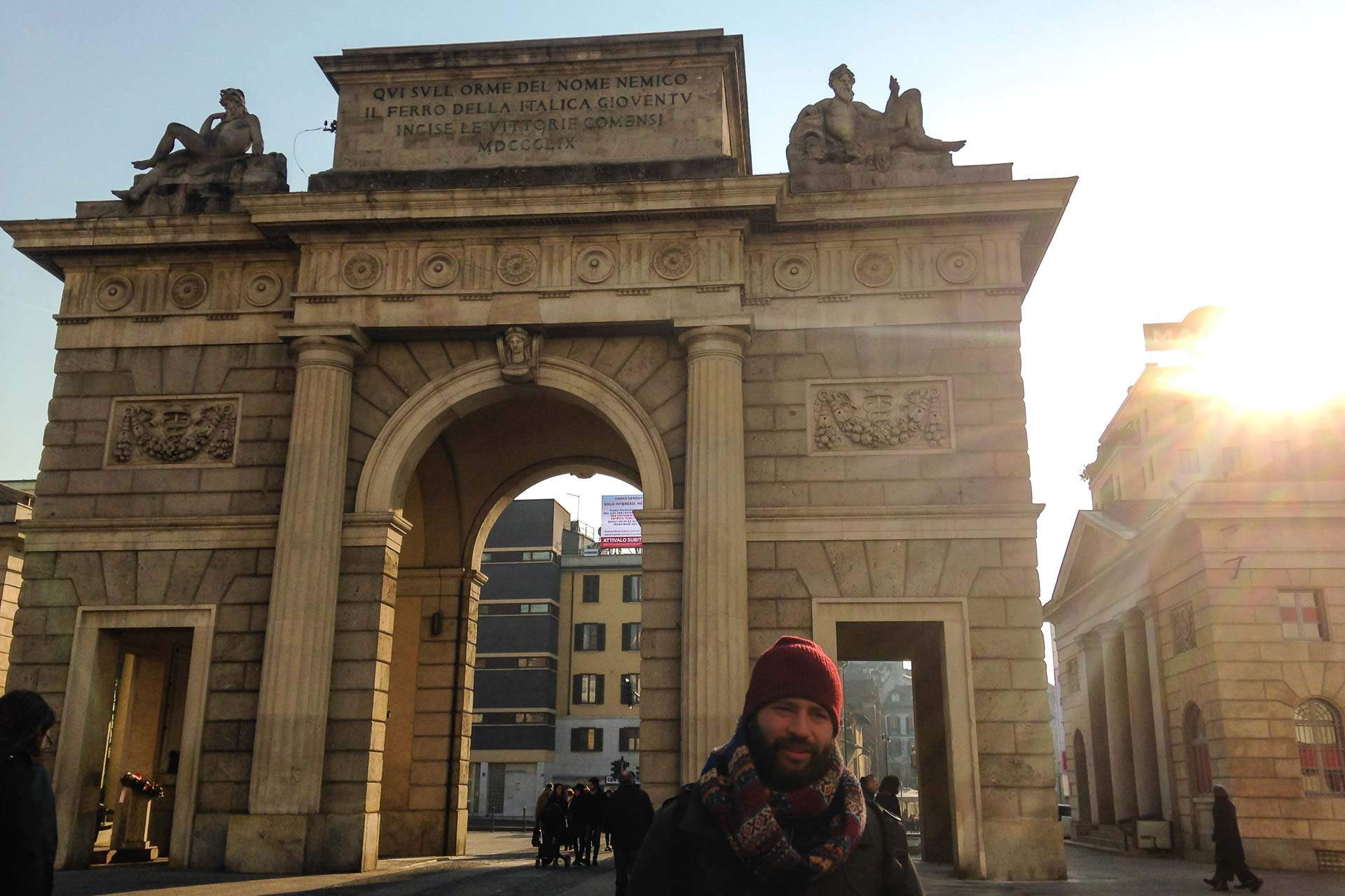 Tiago in front of an arch in Milan with the sun on the corner