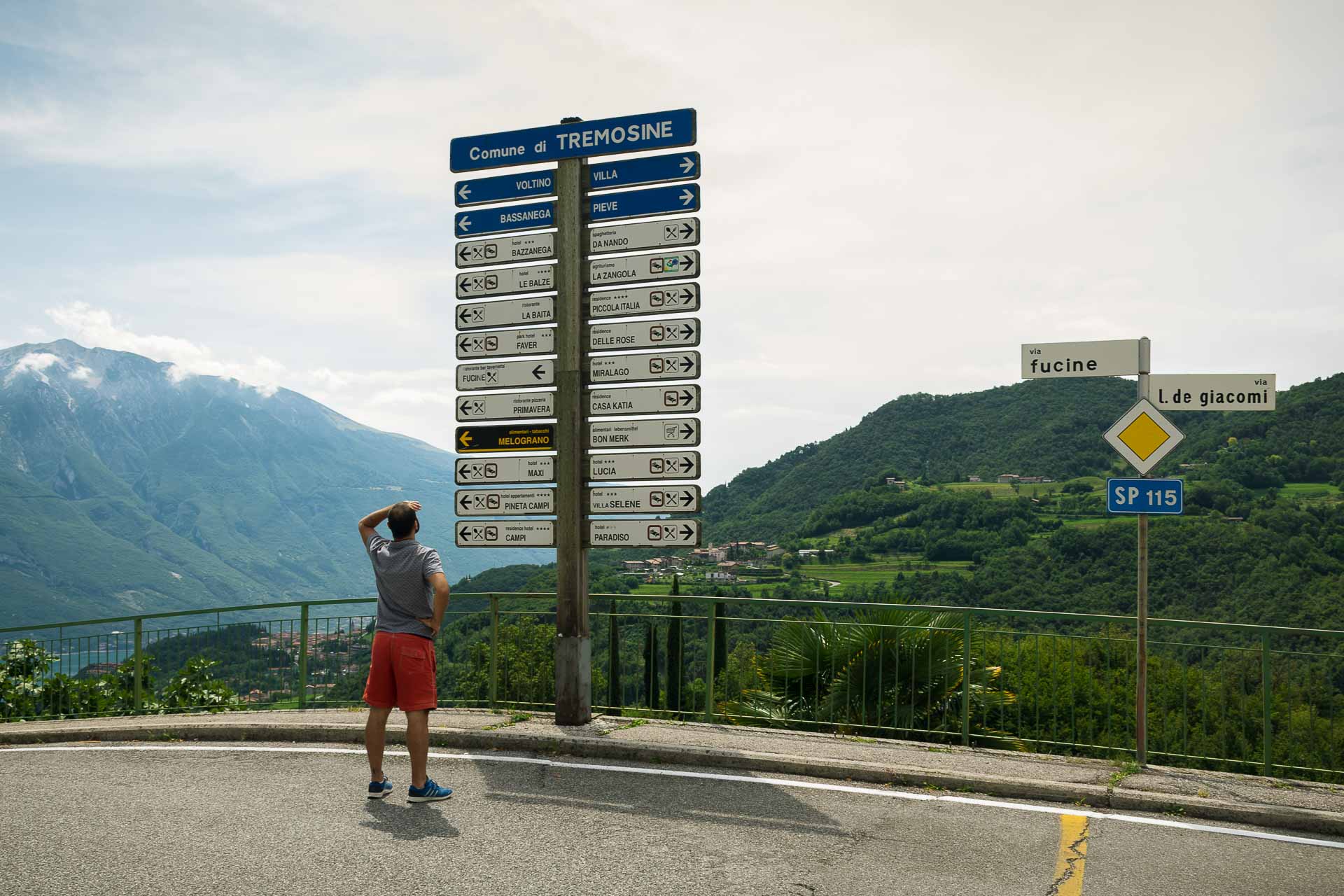 Tiago em frente a uma placa com muitas direções parecendo perdido na Itália