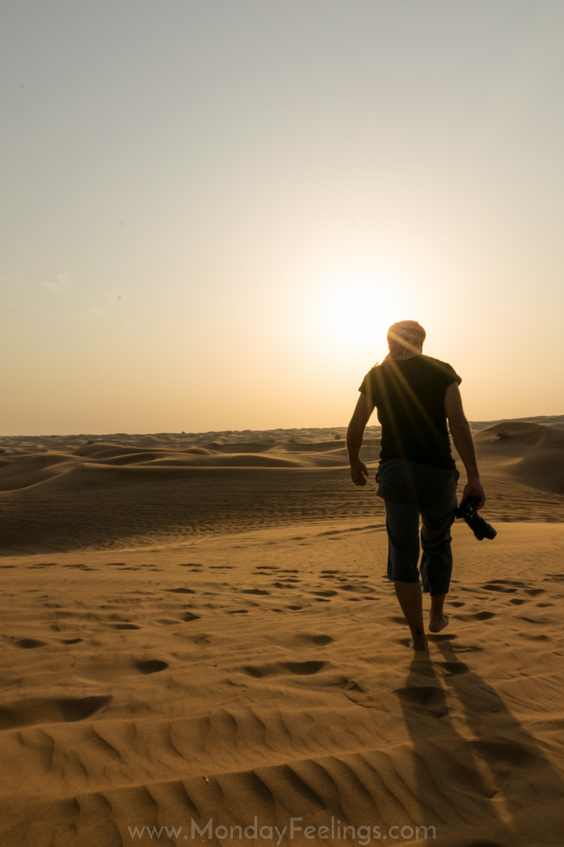 Tiago andanda pelas dunas do deserto de Dubai com uma camera na mão