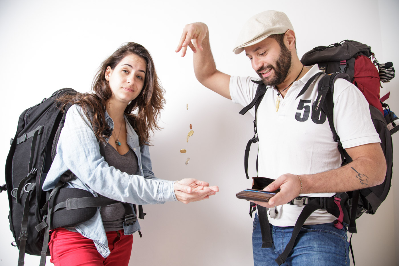 Fernanda e Tiago jogando moedinhas no ar com seus mochilões