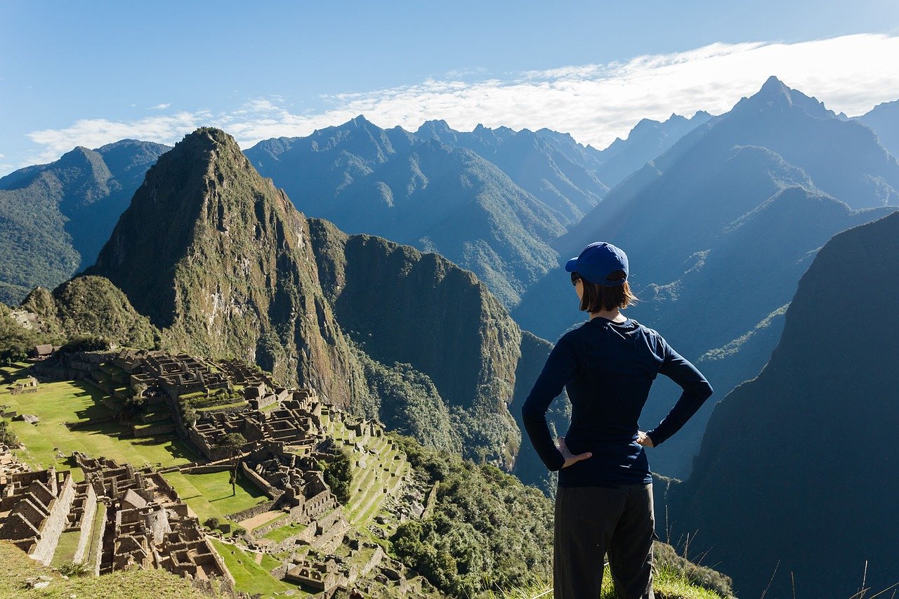 Woman looking to Macchu Picchu from above with the mountains in the background