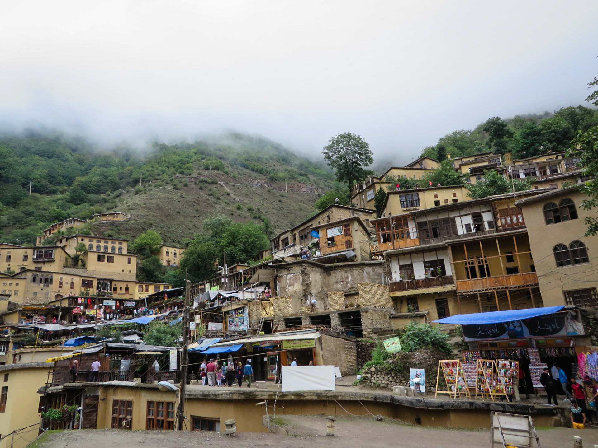 houses on top of houses in a mountain with fog in the background