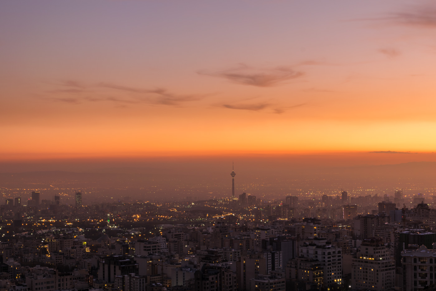 Overview of the city of Tehran with the sun setting colours and the tower standing out