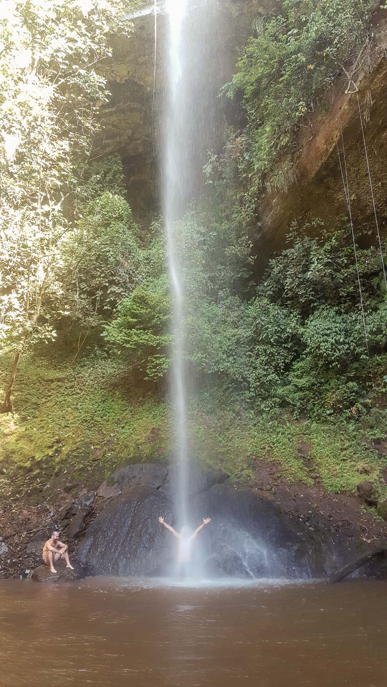 Tiago under a large waterfall in Brazil