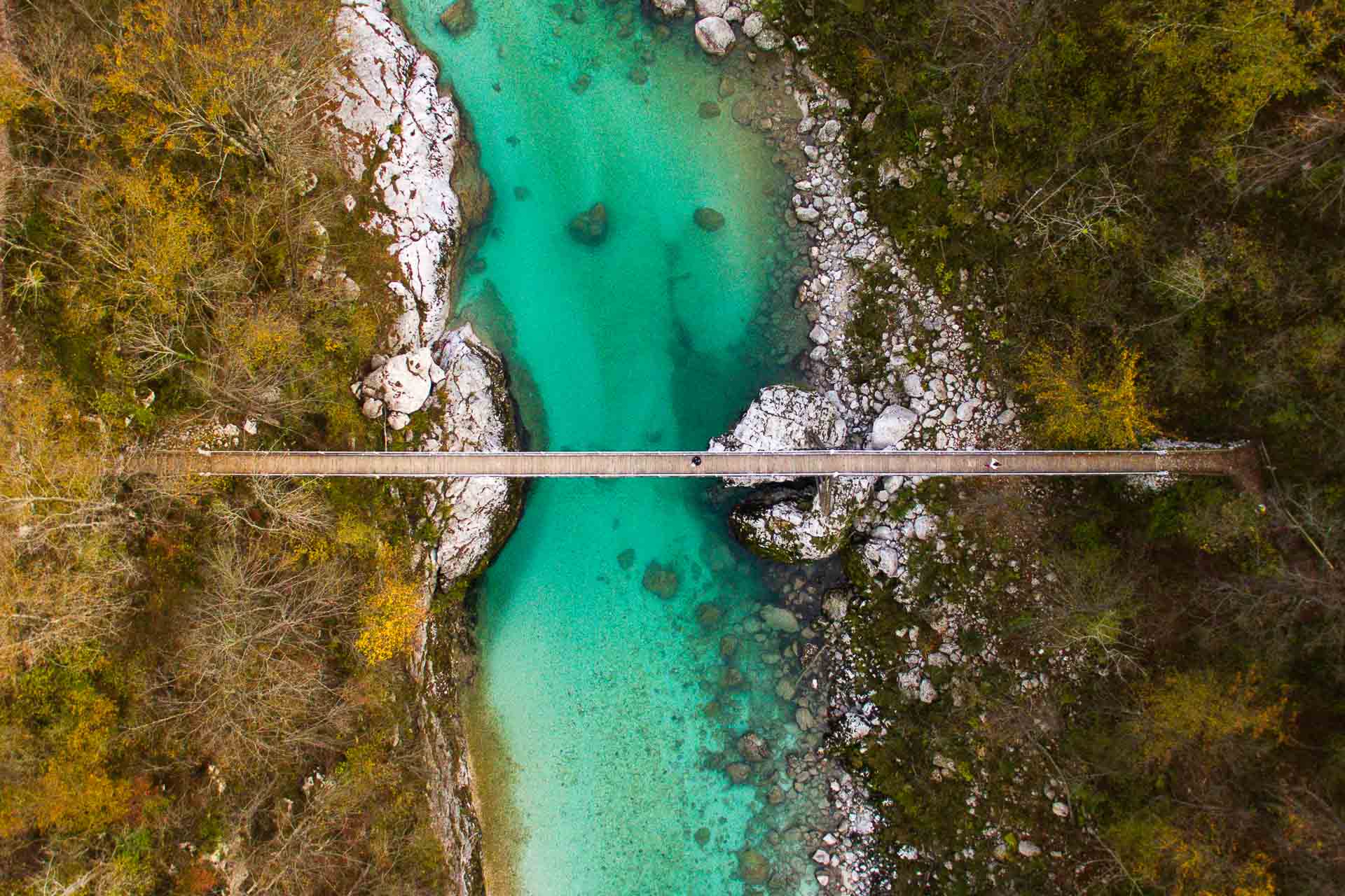 Uma ponte atravessando o rio verde-esmeralda em Kobarid em uma rota de bicicleta na Eslovênia