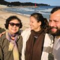 Um senhora coreana, Fernanda e Tiago na frente da praia da Coreia do Sul