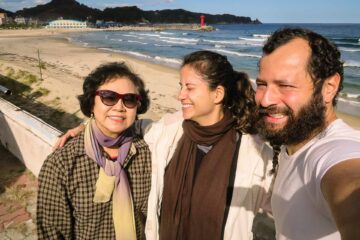 A korean lady, fernanda and Tiago in front of a beach in South Korea
