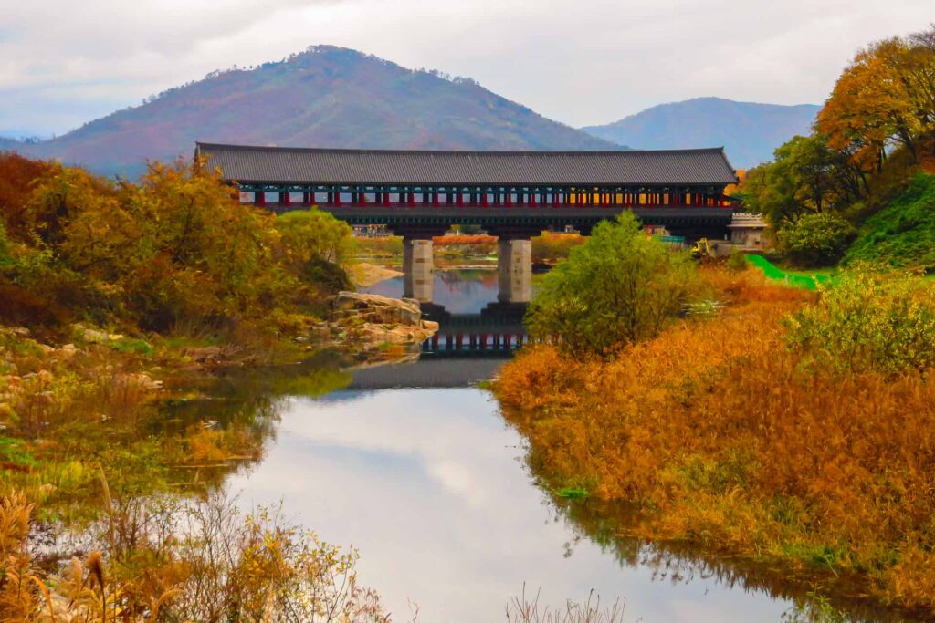 A traditional South Korean bridge on top of a river surrounded by nature