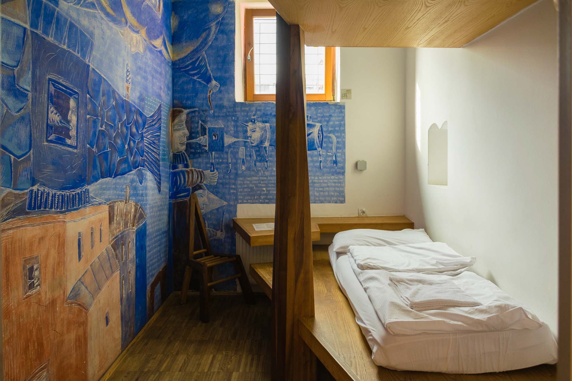 Um dos quartos do hostel celica pintado de azul e bem apertado