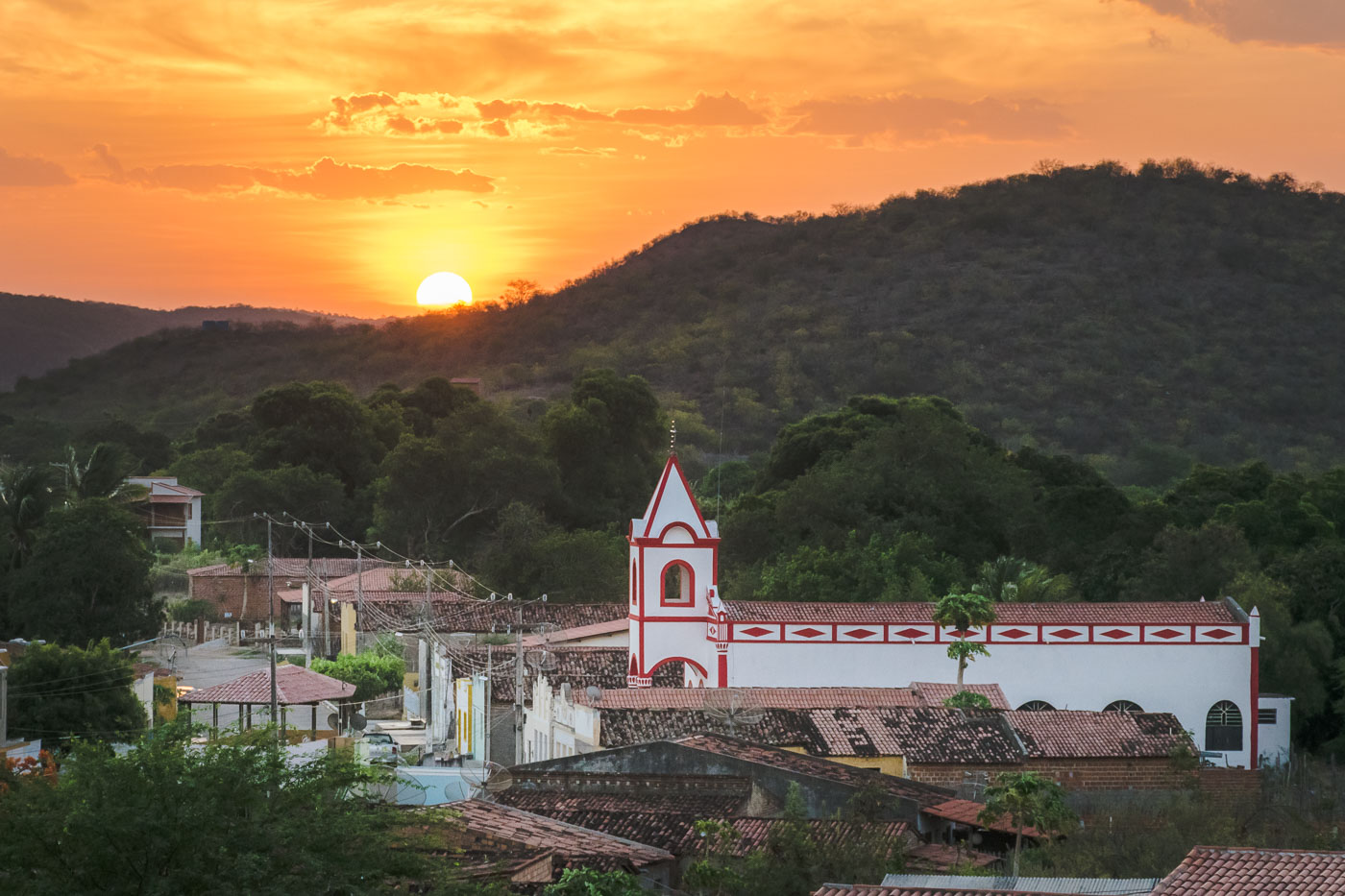 Por do sol da Ilha do Ferro atras da montanha com a igreja da cidade e as casas da única rua