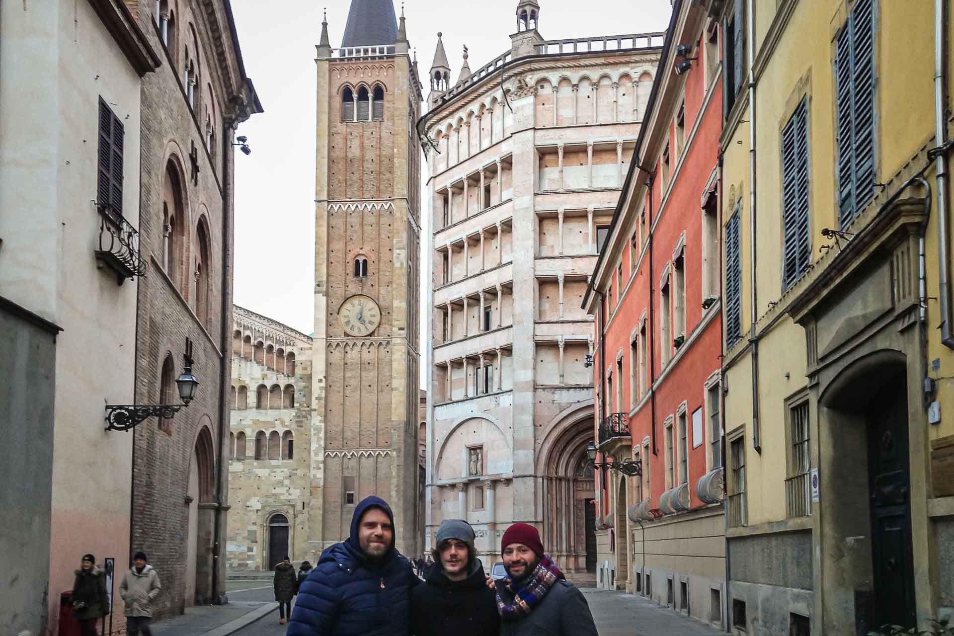 a street of Parma with the Battisterio in the background and Tiago with his cousins