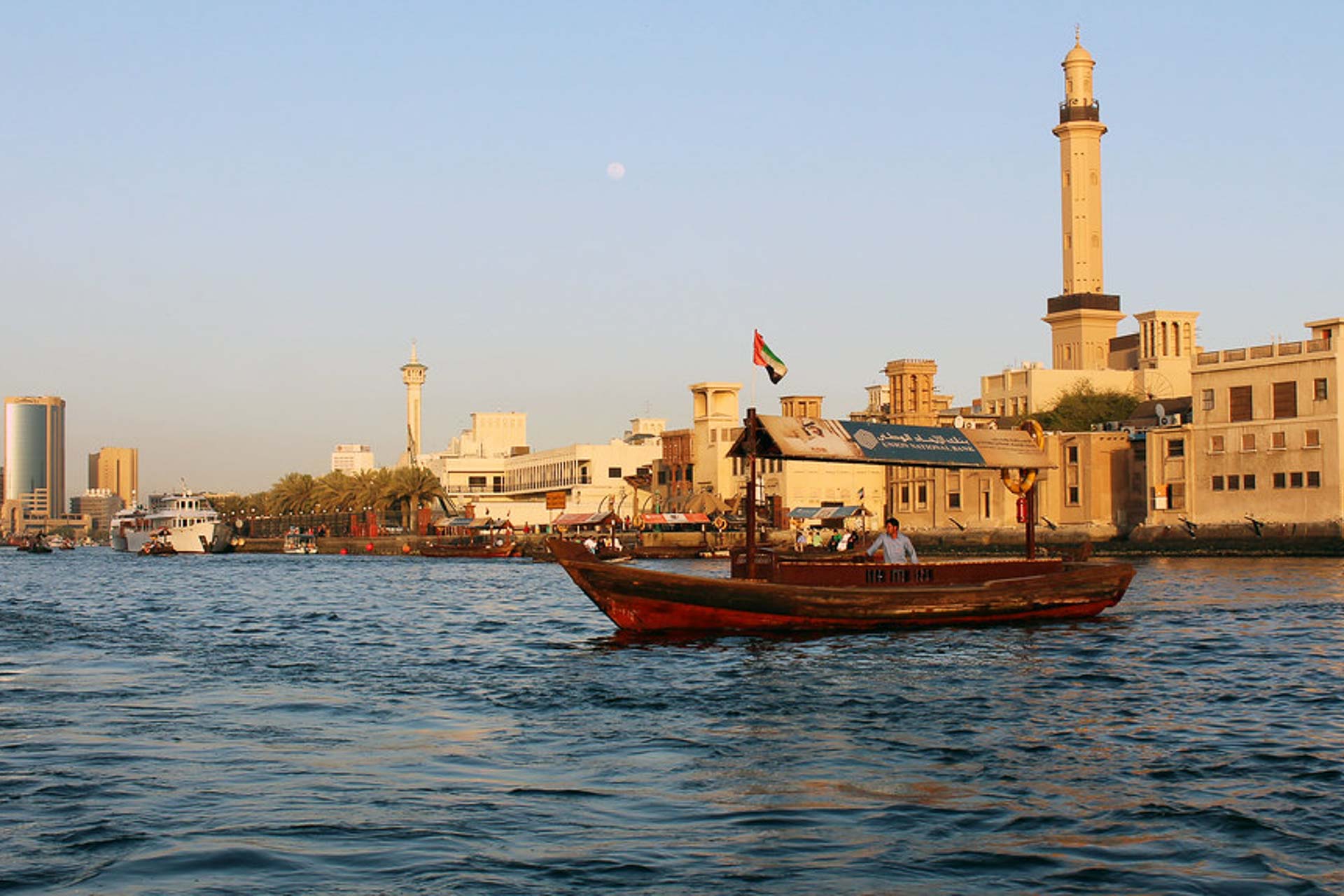 A traditional Emirati boat in front of a mosque in Dubai