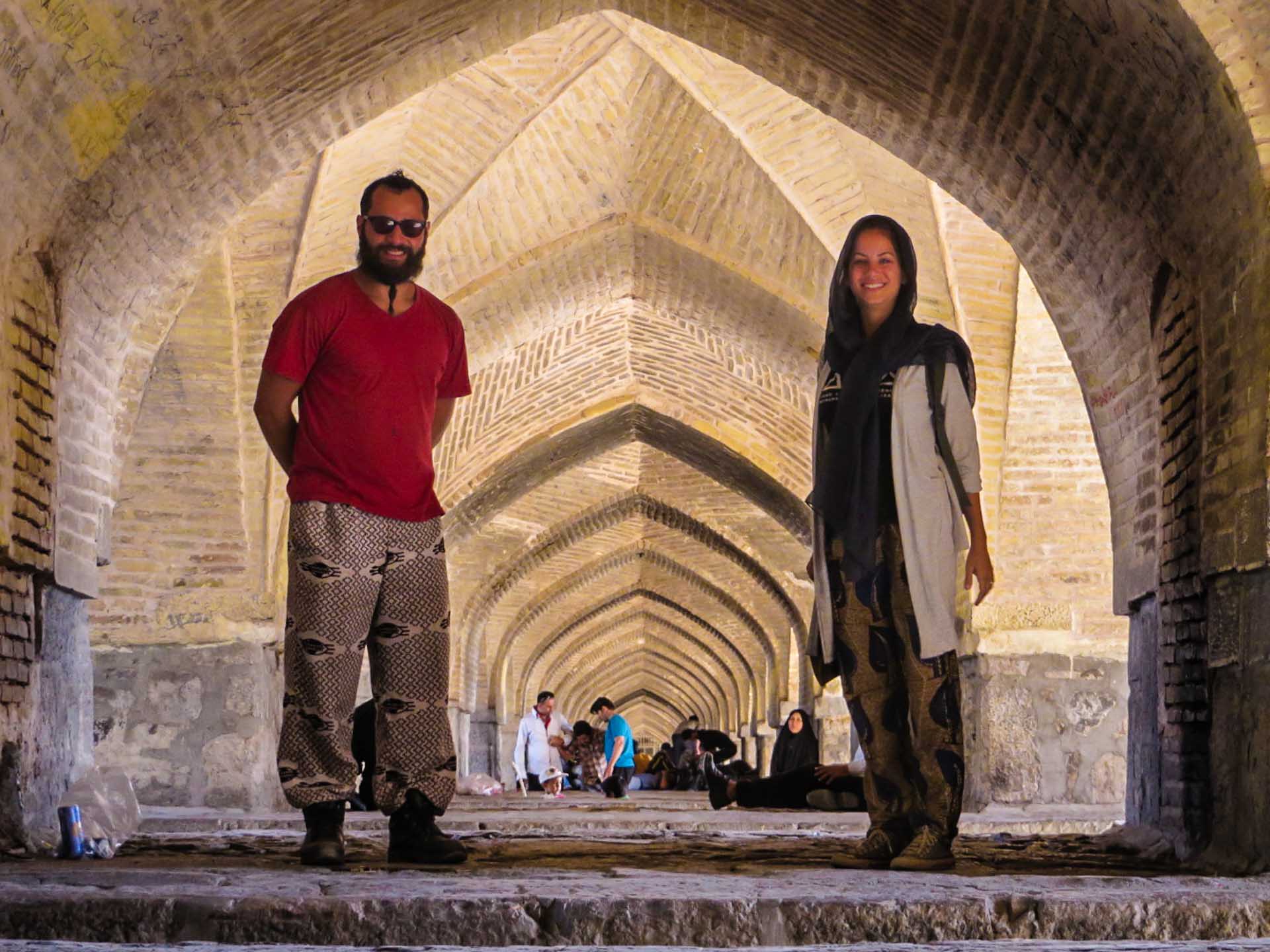 Fernanda e Tiago em pé na galeria embaixo da ponte Si-o-se Pol em Esfahan