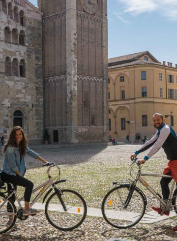 Tiago and Fernanda posing with their bike in front of the main cathedral of Parma