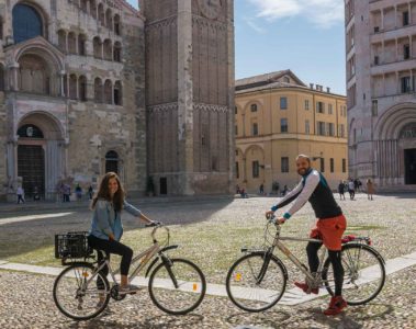 Tiago and Fernanda posing with their bike in front of the main cathedral of Parma