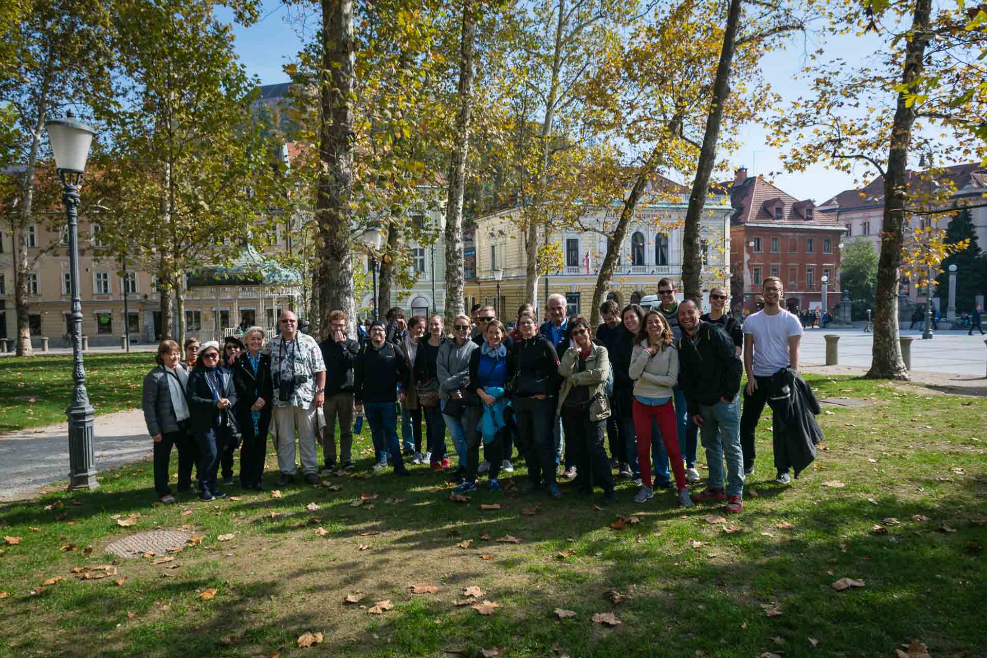 A group of people posing for a picture in a square in Ljubljana after the free walking tour