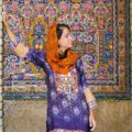 Fe with colourful clothes in front of a mosque with colourful tiles