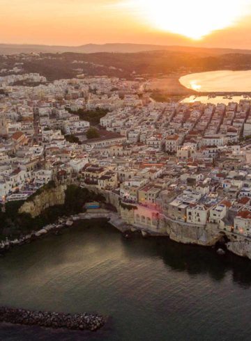 Vista aerea de Vieste na Puglia, rodeada pelo mar durante o por do sol