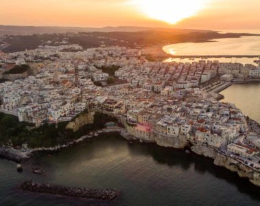 Vista aerea de Vieste no sul da Italia envolta pelo mar com o sol se pondo