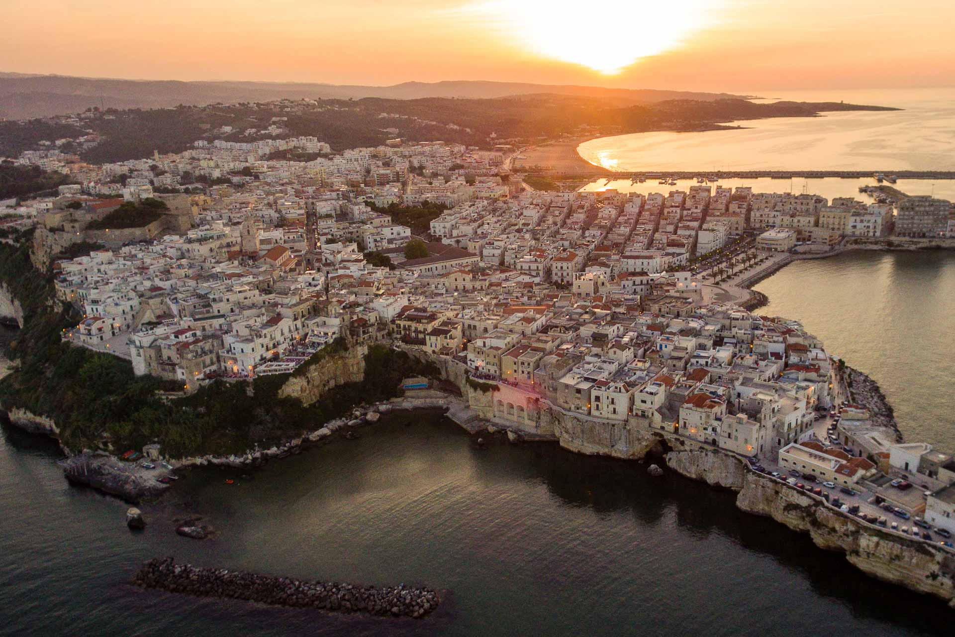 Aerial view of Italian city surrounded by the sea at sunset