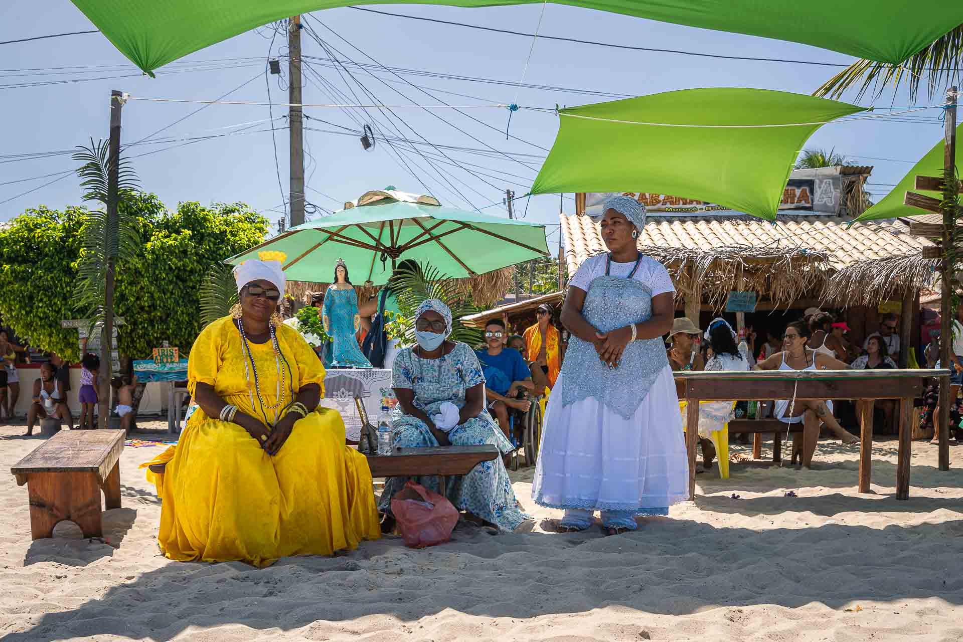 Tipicas baianas sentadas na frente da estatua de Iemanjá na praia de Morere