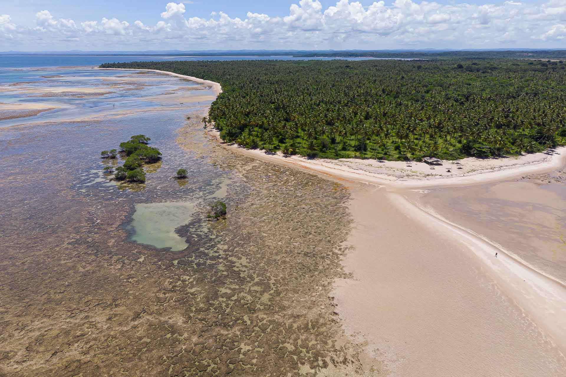 View of the corner of the island with half sand and half coral reefs and a natural pool