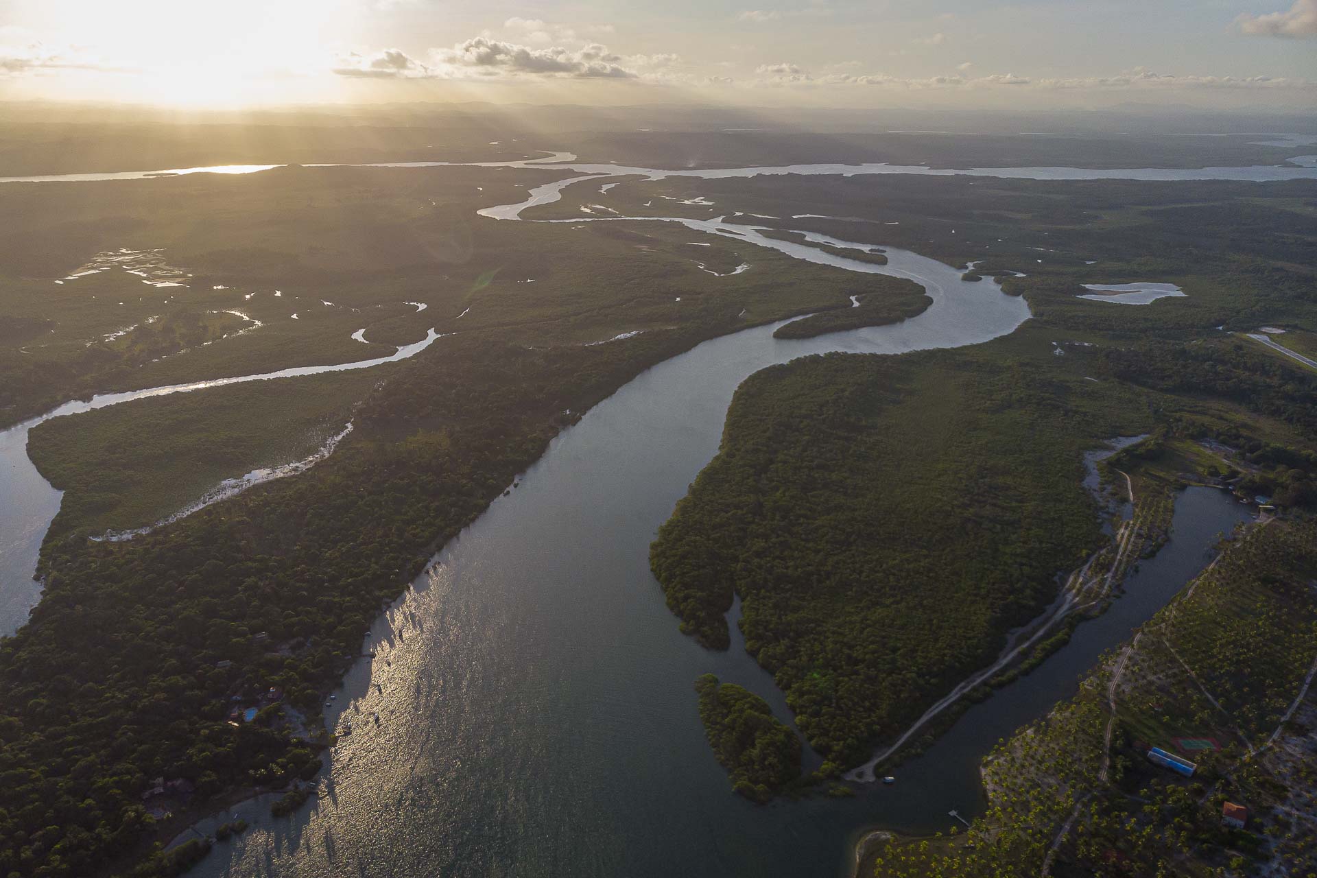 Vista do alto da Ilha de Boipeba na Bahia cercada de rios e com o sol se pondo no horizonte