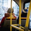 two woman sitting in the front seat of a double-decker bus in London