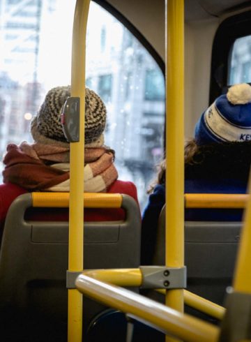 two woman sitting in the front seat of a double-decker bus in London