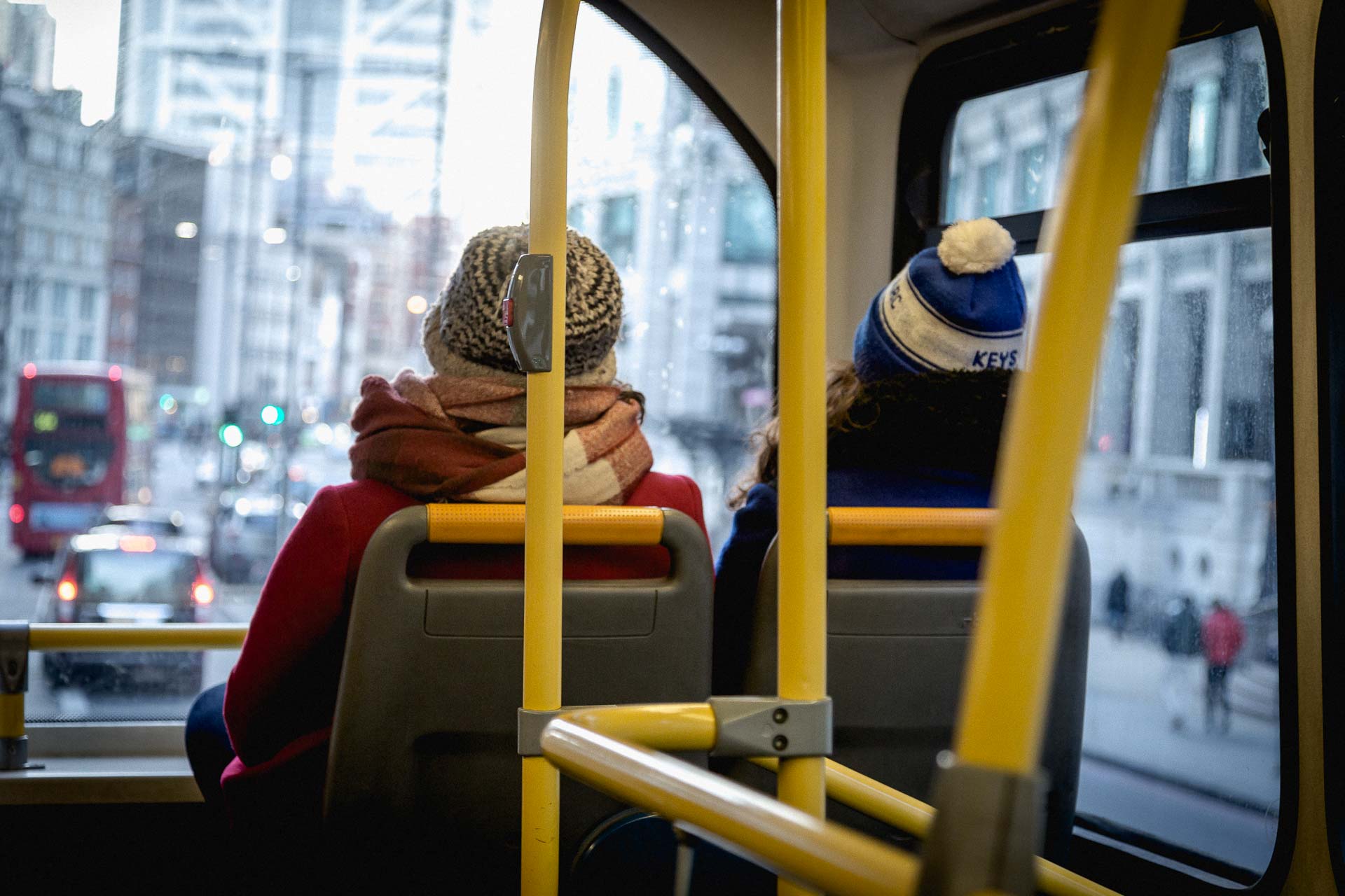 two woman sitting in the front seat of a double-decker bus in London