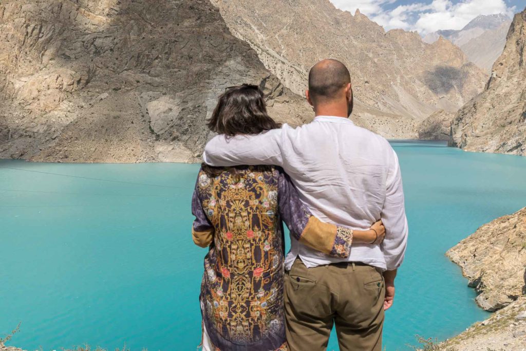 Tiago e Fernanda abraçados olhando para o Lago Attabad de cor azul turquesa no Vale de Hunza