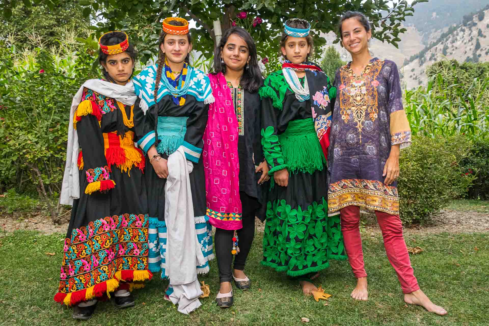 Cinco mulheres vestidas bem coloridas como as Kalash no Vale de Kalash no Paquistão