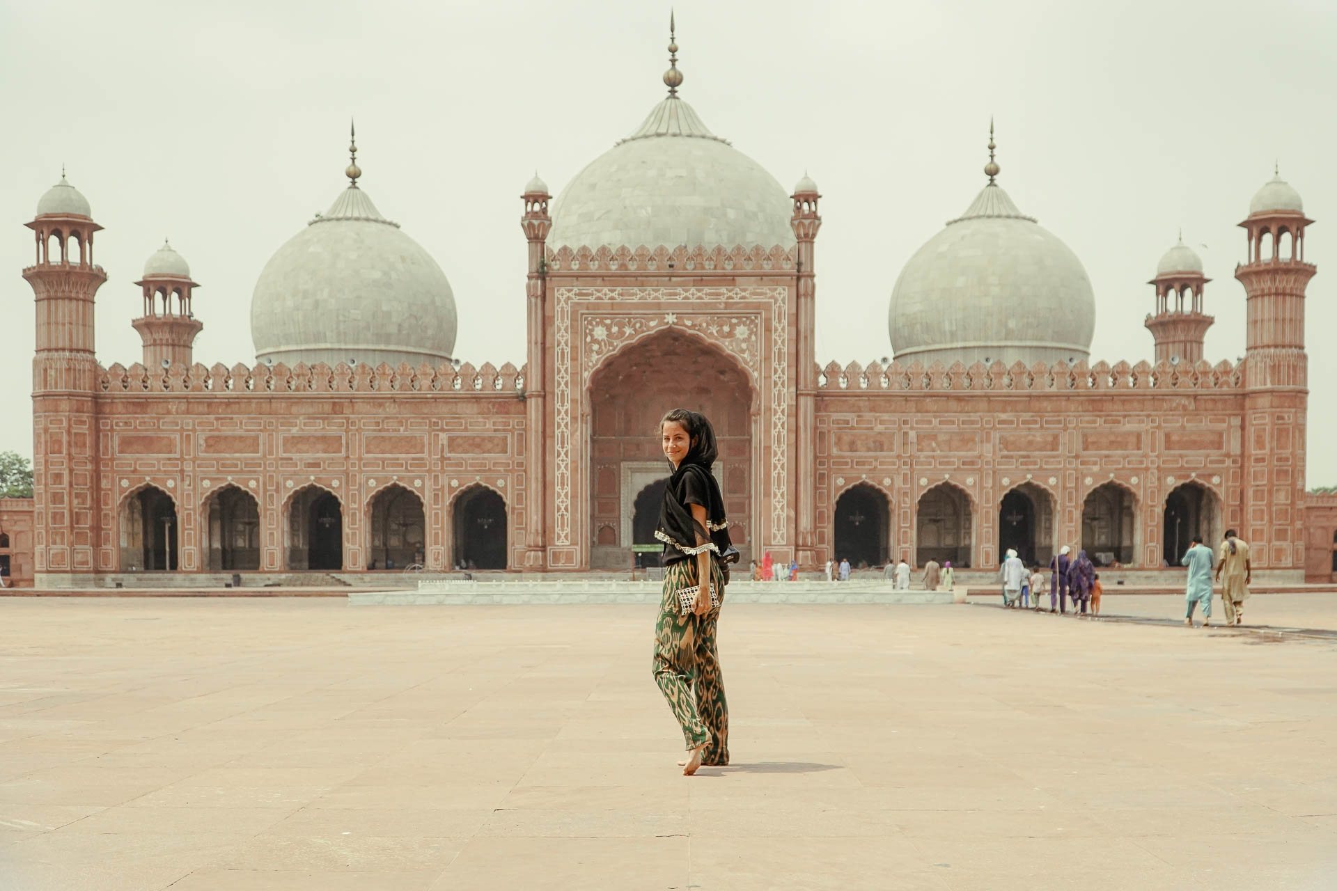 Fernanda in the middle with a mosque with three domes in the background in a large 