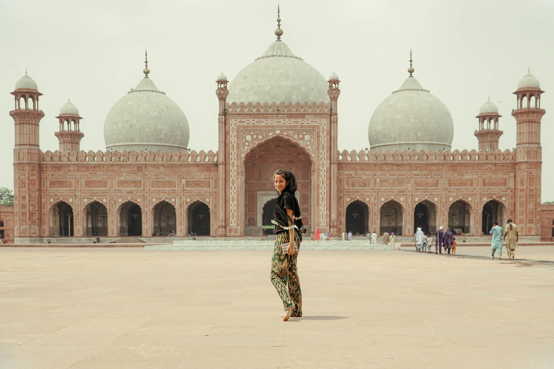 Fernanda in the middle with a mosque with three domes in the background in a large yard