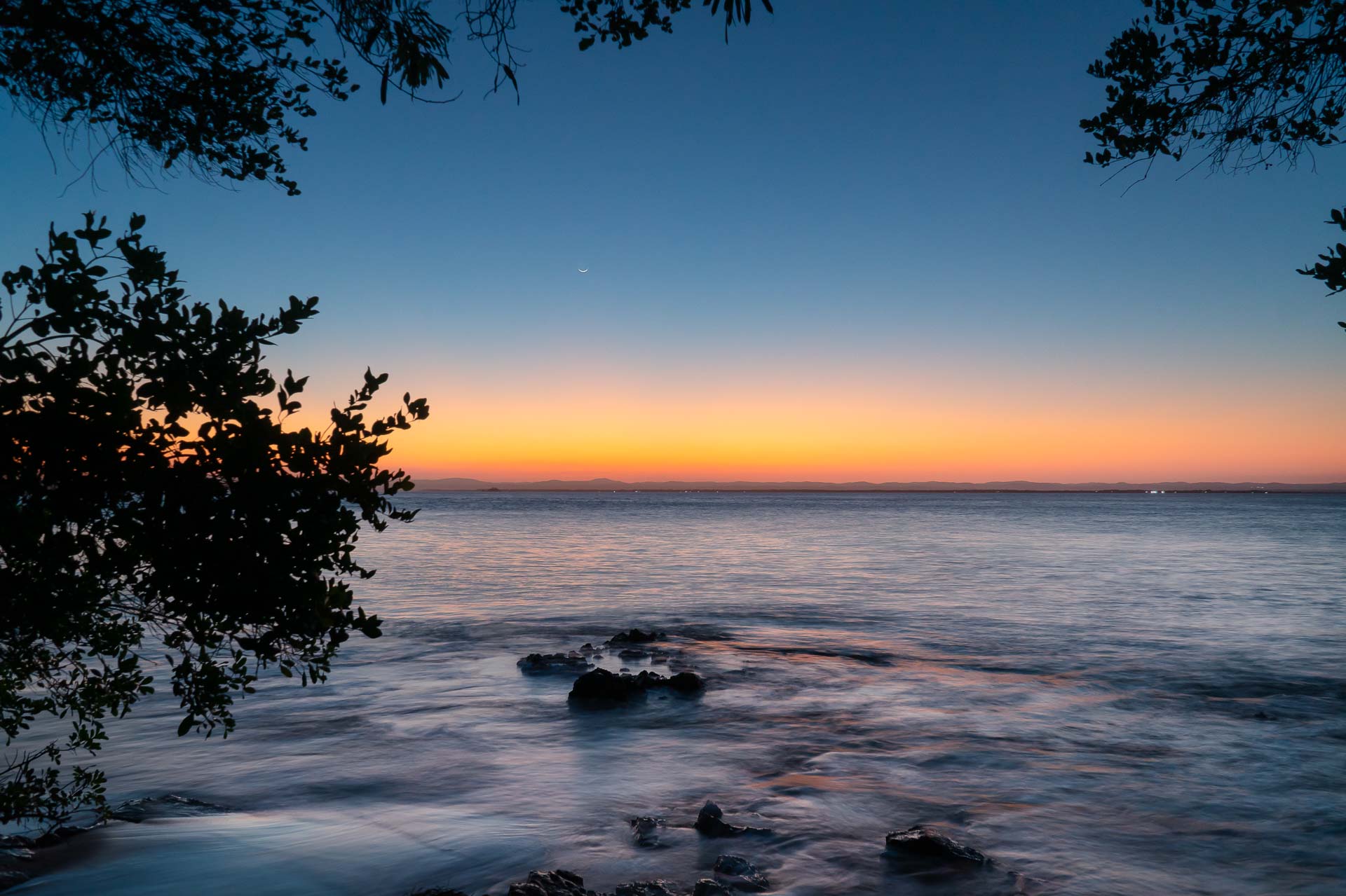 Aguas do mar batendo nas pedras ao entardecer na ponta do muta